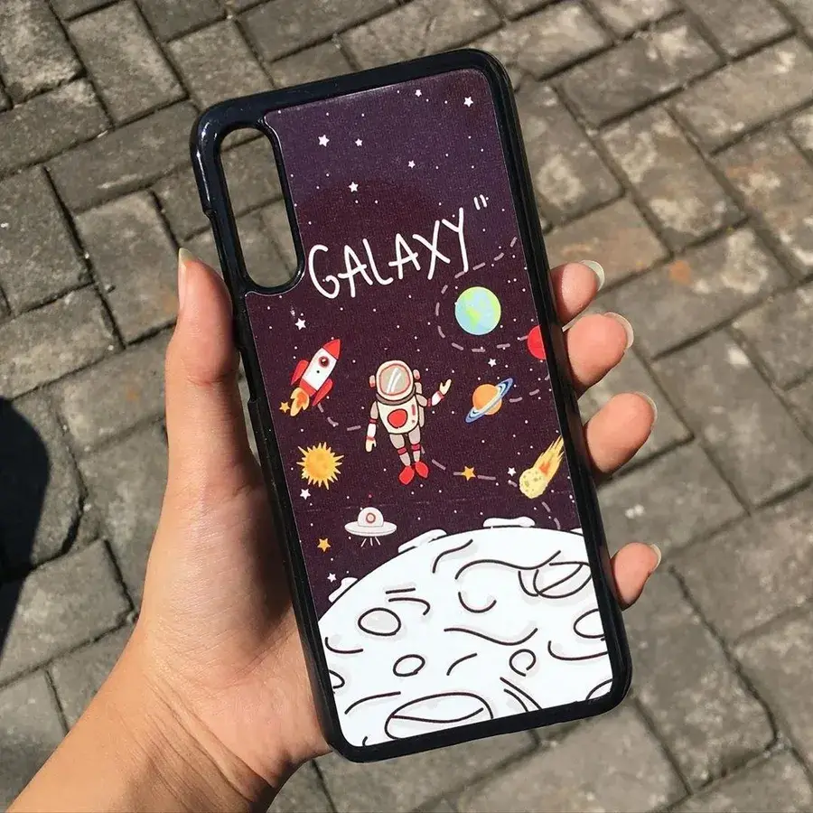 Hardcase custom Cuztoom bermotif astronot dan galaksi dipegang di tangan