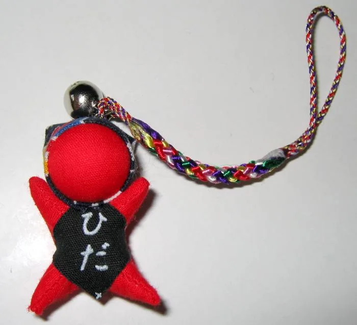 Gantungan HP boneka kain merah khas Jepang dengan tali anyaman warna-warni dan lonceng kecil