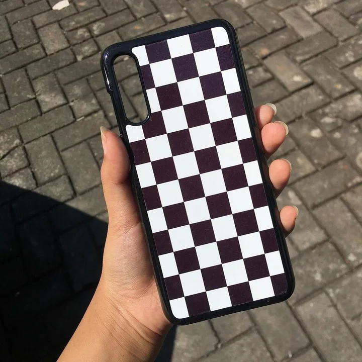 Hardcase custom Cuztoom bermotif kotak hitam putih dipegang tangan
